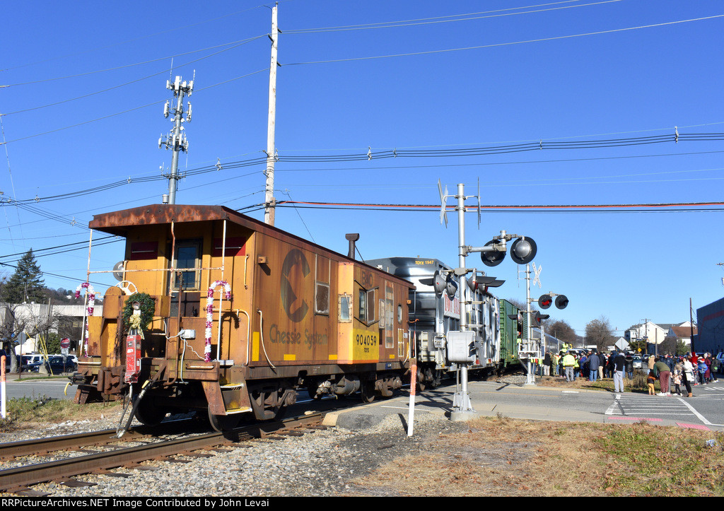 Chessie System Caboose # 904059 is on the rear of the train as it blocks the Central Avenue Grade Crossing as a healthy crowd partakes in the festivities